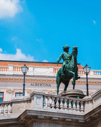 Low angle view of statue against blue sky