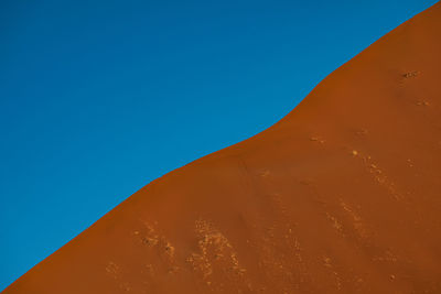 Sand dune profile against blue sky in namib desert 