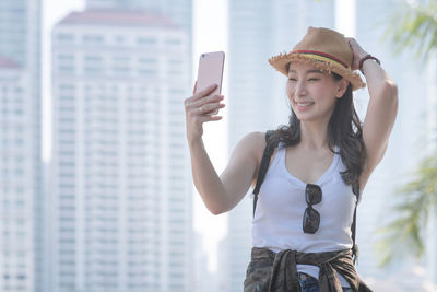 Young woman photographing with mobile phone