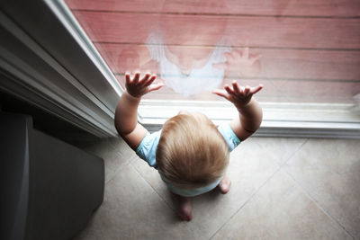 Boy standing against window