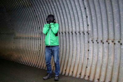 Rear view of man standing against wall