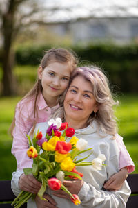 Portrait of smiling young woman holding bouquet