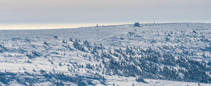 Snow covered land against sky