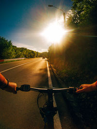 Man riding bicycle on road against sky