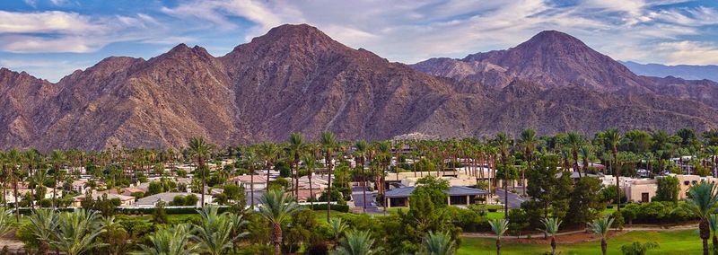 Panoramic view of houses and mountains against sky