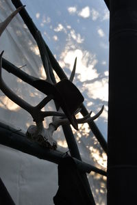 Low angle view of silhouette built structure against cloudy sky