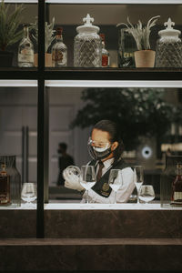 Woman serving wine in store