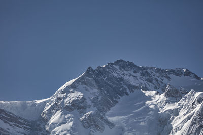 Scenic view of snowcapped mountains against clear sky