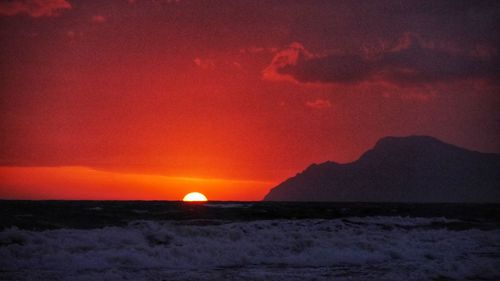 Scenic view of sea against romantic sky at sunset