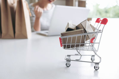 Close-up of match boxes in small shopping cart on table