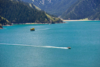 A boat sailing in the beautiful landscape of tianchi lake in the tianshan mountains.