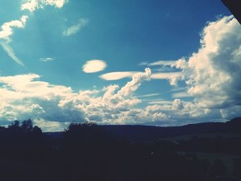 Low angle view of silhouette trees against sky