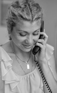 Smiling woman talking on telephone at home