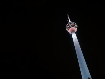 Low angle view of menara kuala lumpur tower against sky at night