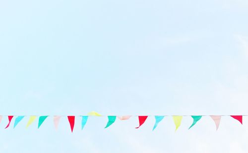 Low angle view of colorful flags against clear sky