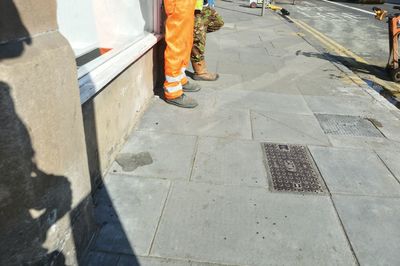 Low section of people standing on sidewalk