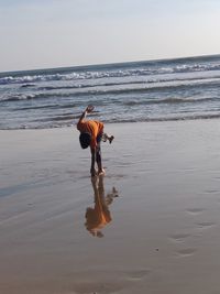 Rear view of person on beach against sky
