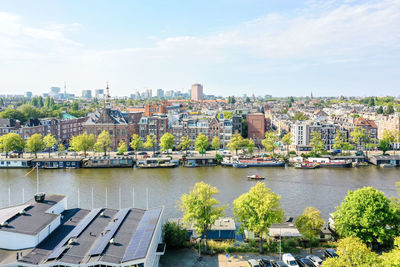 River and buildings in city against sky