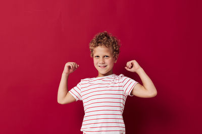 Portrait of boy standing against yellow background