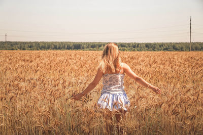 Full length of woman standing in farm against sky