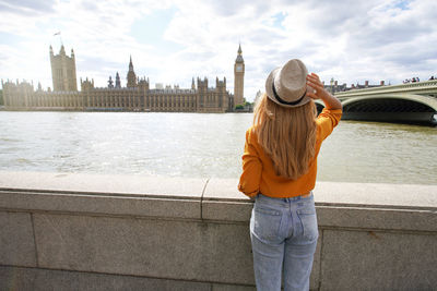 Girl visiting london with westminster palace and bridge on thames river and big ben tower in england