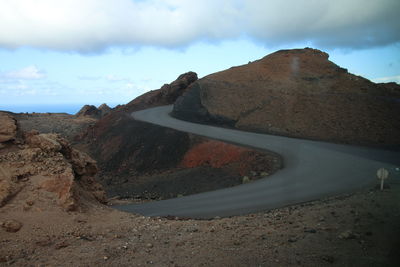 Road by mountain against sky