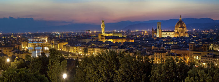 High angle view of city lit up at sunset