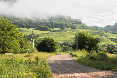 Road amidst field against sky