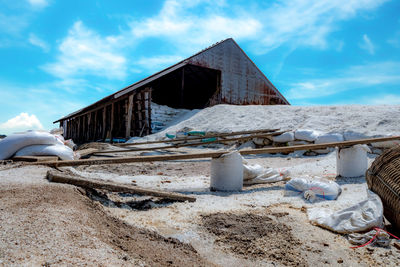 Old abandoned building on field against sky