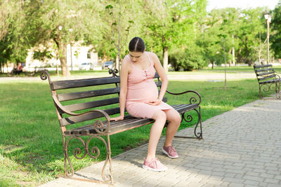 Woman sitting on bench in park