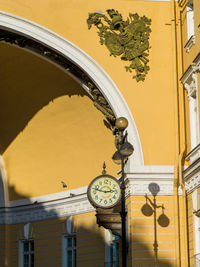 Low angle view of clock on wall against building