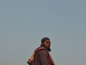 Portrait of young man standing against clear sky