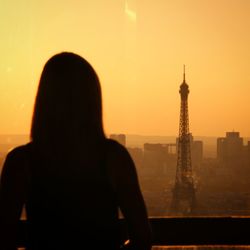 Rear view of silhouette woman looking at sunset