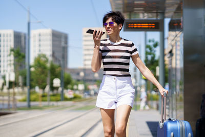 Young woman using mobile phone in city