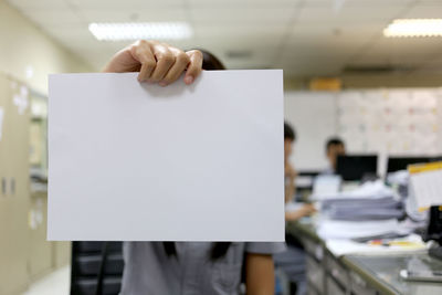 Midsection of woman holding paper with text