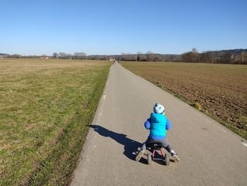 Rear view of boy riding motorcycle on road