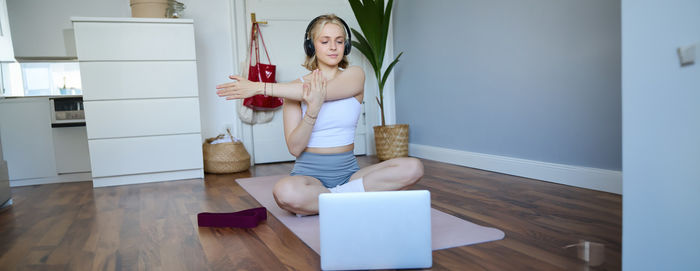 Rear view of woman using mobile phone while sitting on table