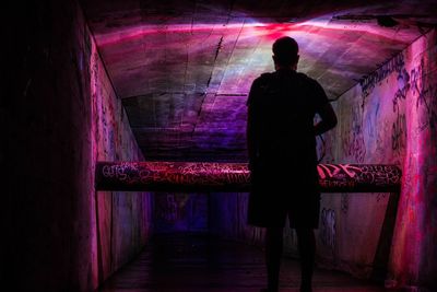 Rear view of silhouette man standing in subway