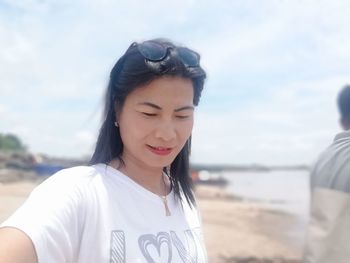 Portrait of woman on beach against sky