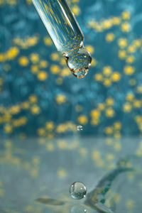 A dripping pipette with a drop of cosmetics gel.