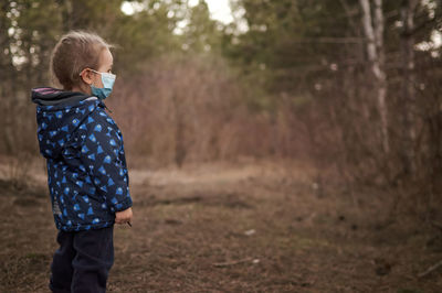 Side view of boy standing on land