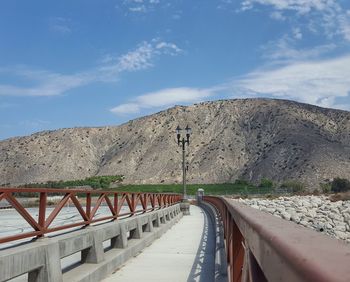 Road by mountain against sky