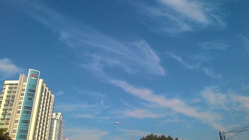 Low angle view of skyscrapers against blue sky