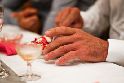 Midsection of man holding ice cream on table