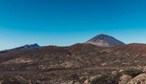 View of volcanic mountain against blue sky