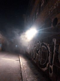 Street against illuminated buildings in city at night