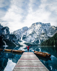 Rear view of person on snowcapped mountain against sky