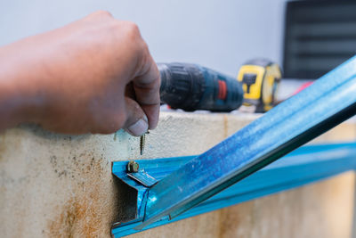 Cropped hand of man repairing pipe