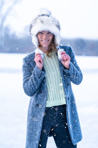 Portrait of young woman standing on snow