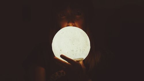 Close-up of hand holding illuminated lamp